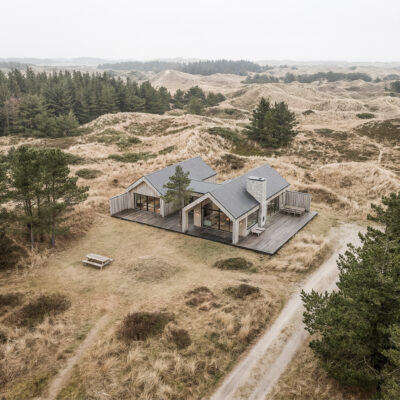 Arkitekttegnet helårshus i klitlandskab med træfacader